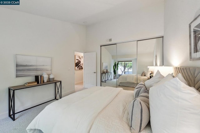 bedroom with light colored carpet and a closet