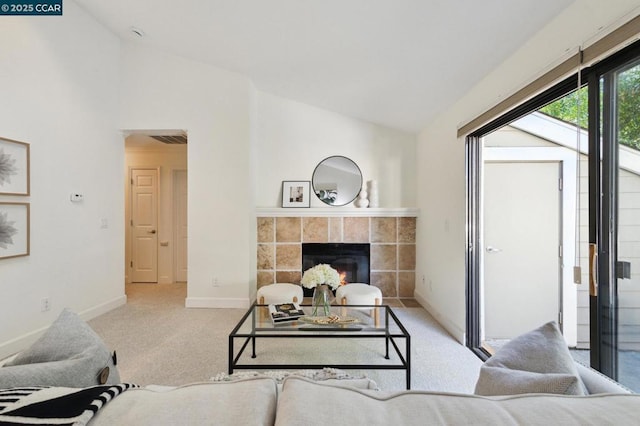 living room featuring a fireplace, light colored carpet, and vaulted ceiling