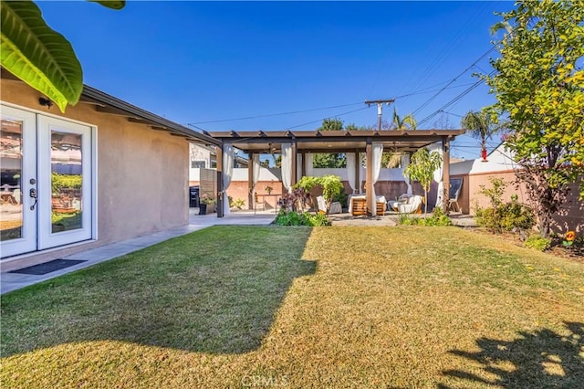 rear view of property with french doors, a patio area, and a yard