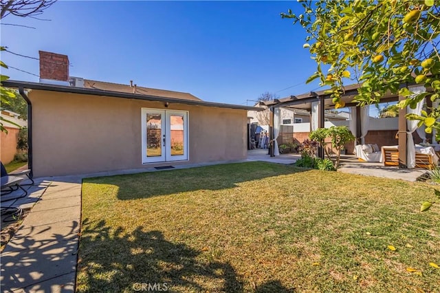 rear view of property featuring a patio, french doors, and a yard