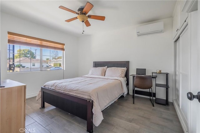 bedroom featuring dark wood-type flooring, a wall mounted AC, ceiling fan, and a closet