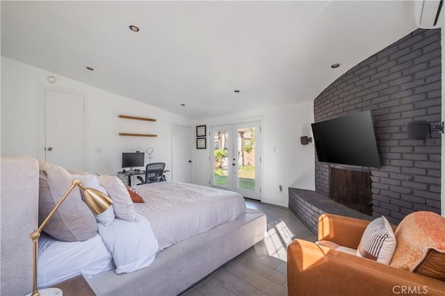 bedroom with french doors, a brick fireplace, access to exterior, and vaulted ceiling