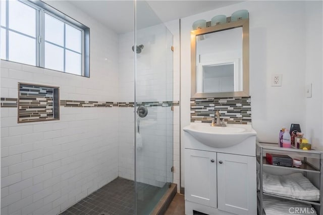 bathroom with vanity, decorative backsplash, and a shower with shower door