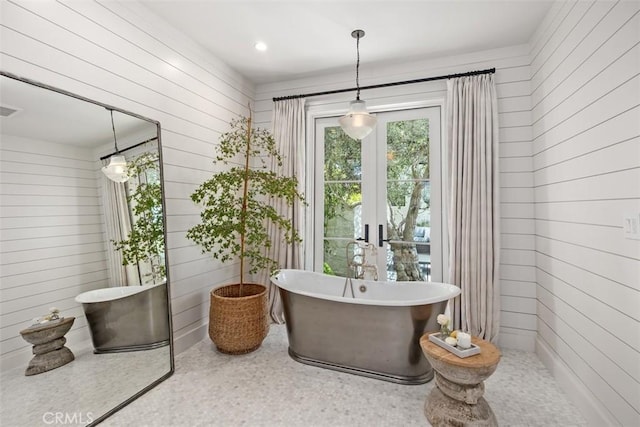 bathroom with wood walls and a tub