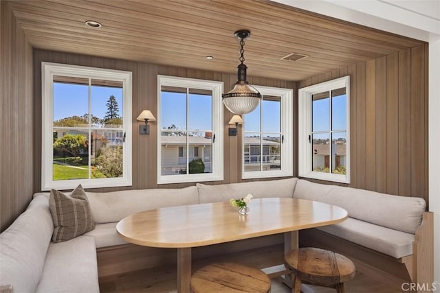 sunroom featuring a healthy amount of sunlight, wood ceiling, and breakfast area