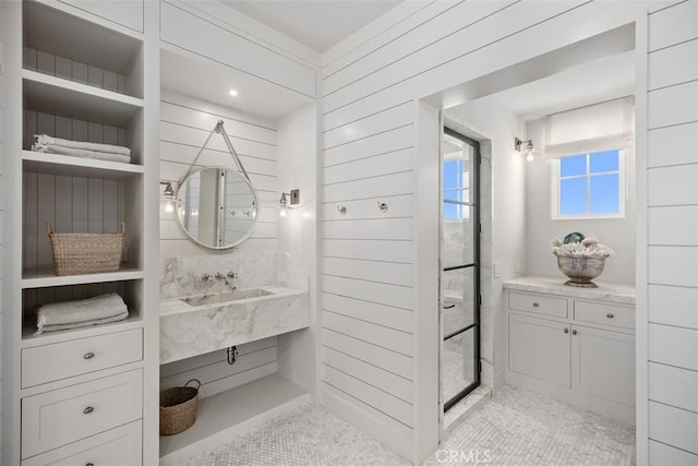 bathroom with walk in shower, wooden walls, and vanity