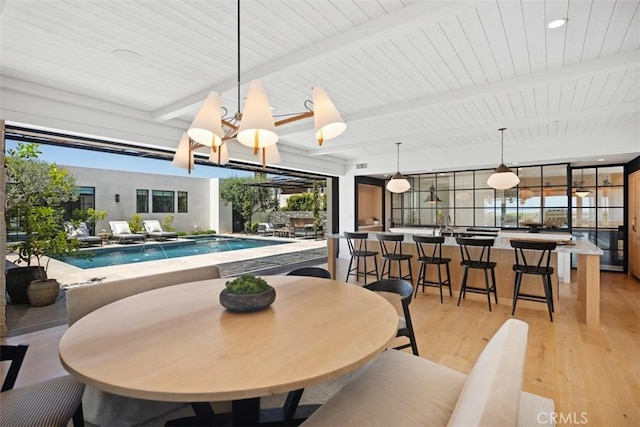 dining space with an inviting chandelier, a wealth of natural light, and light hardwood / wood-style floors