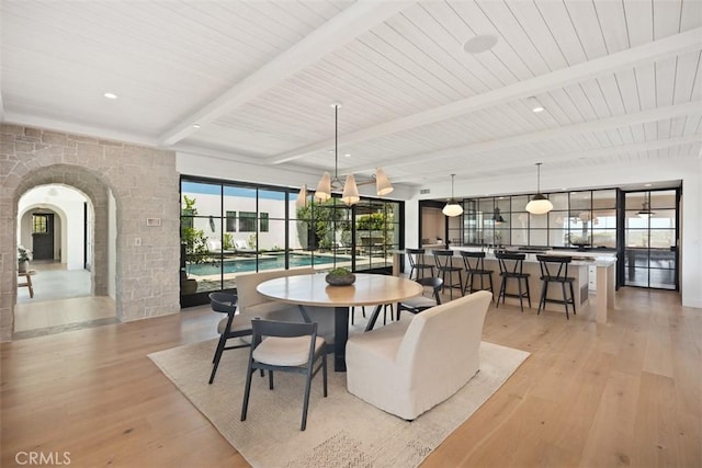 dining area featuring beam ceiling and light hardwood / wood-style flooring