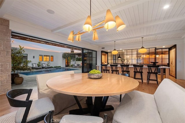 dining area with beamed ceiling and light hardwood / wood-style flooring