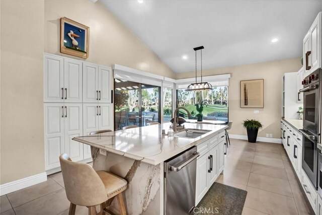 kitchen with sink, white cabinetry, pendant lighting, a kitchen island with sink, and appliances with stainless steel finishes