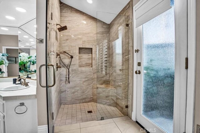 bathroom with tile patterned flooring, walk in shower, and vanity