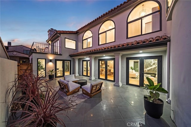 back house at dusk with an outdoor fire pit and a patio