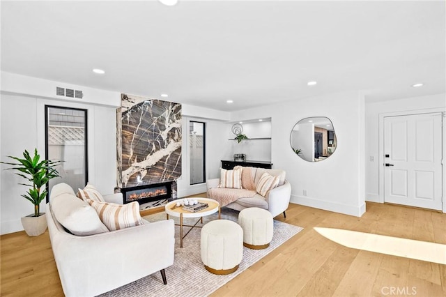 living room featuring wood-type flooring and a high end fireplace