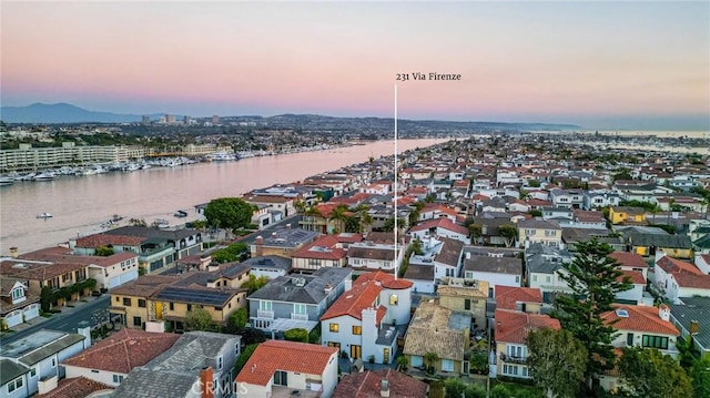 aerial view at dusk featuring a water view