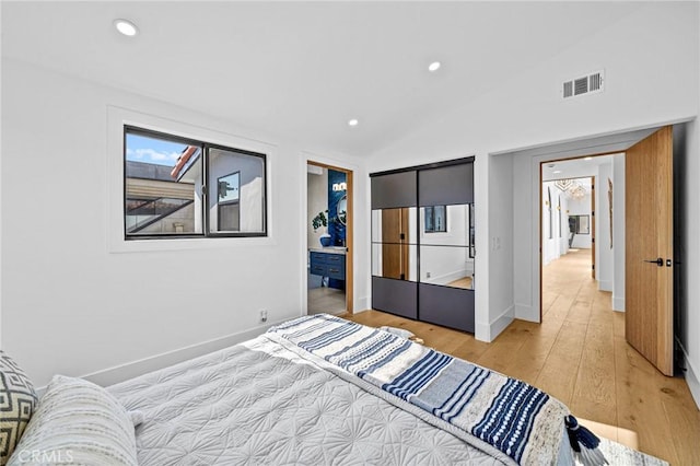 bedroom with light hardwood / wood-style floors and vaulted ceiling