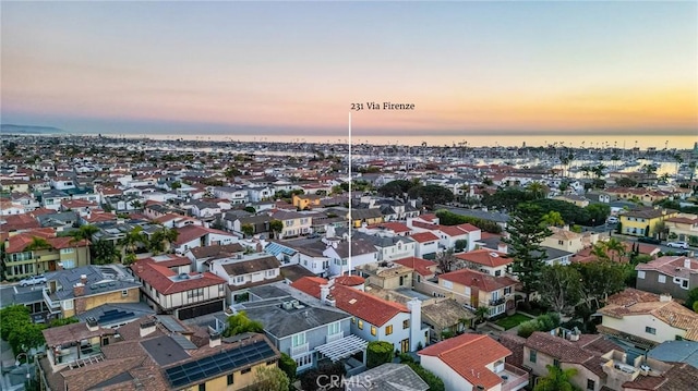 aerial view at dusk featuring a water view