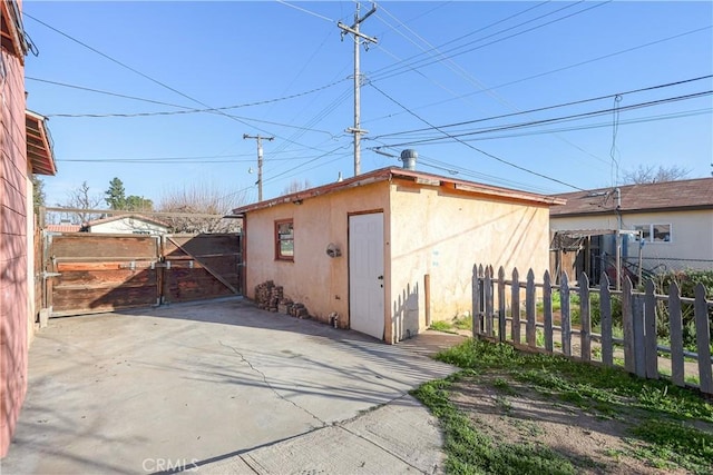 view of outbuilding with an outdoor structure, a gate, and fence