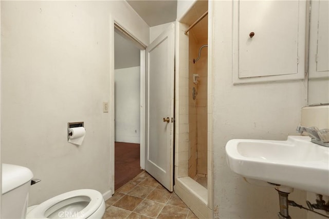 bathroom featuring a sink, baseboards, toilet, and a shower stall