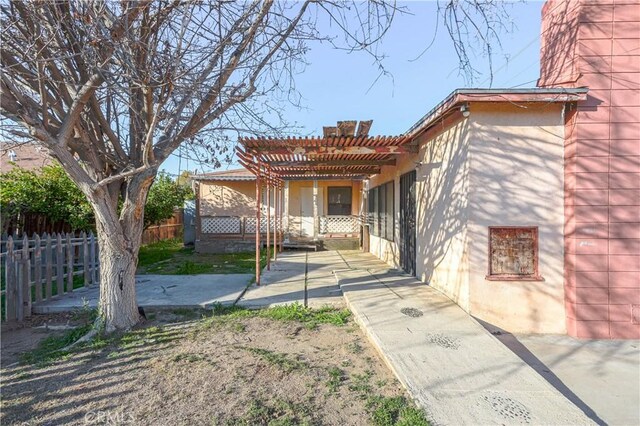 view of front of home with a patio area, a pergola, and fence