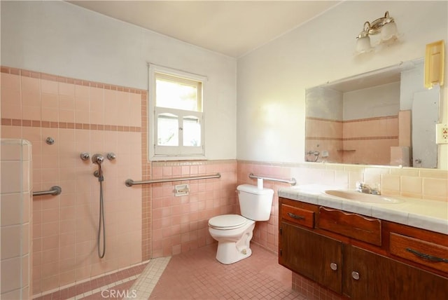 bathroom featuring toilet, tile walls, wainscoting, tile patterned flooring, and vanity