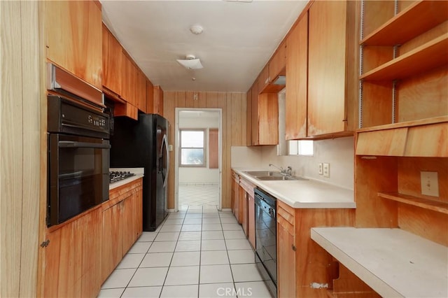 kitchen featuring open shelves, light countertops, light tile patterned floors, black appliances, and a sink