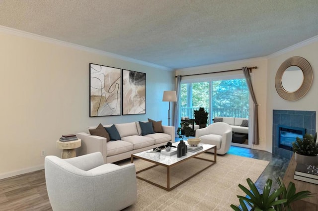 living room with ornamental molding, wood-type flooring, a textured ceiling, and a tiled fireplace