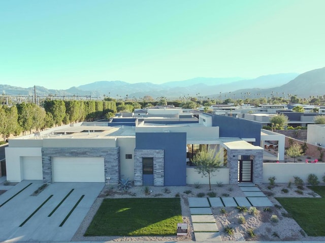 view of front of house featuring a garage, a front yard, and a mountain view