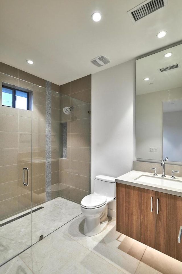 bathroom featuring a shower with door, tile patterned floors, vanity, and toilet