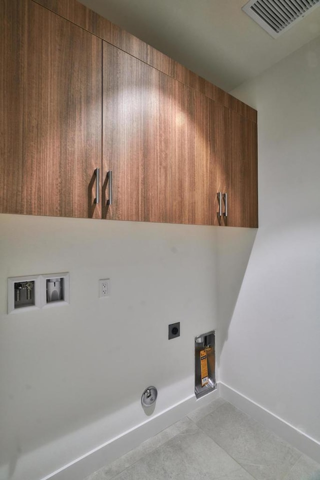 laundry room featuring light tile patterned floors, cabinets, hookup for a washing machine, and hookup for an electric dryer