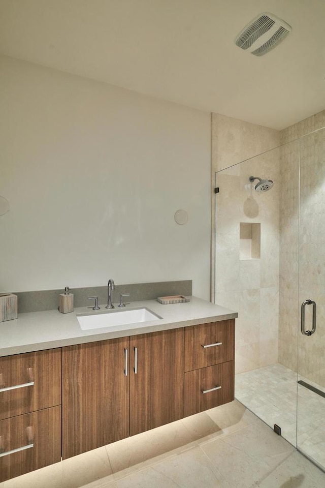 bathroom featuring vanity, tile patterned floors, and a shower with shower door