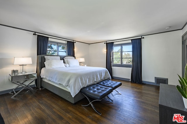 bedroom with dark wood-type flooring and ornamental molding