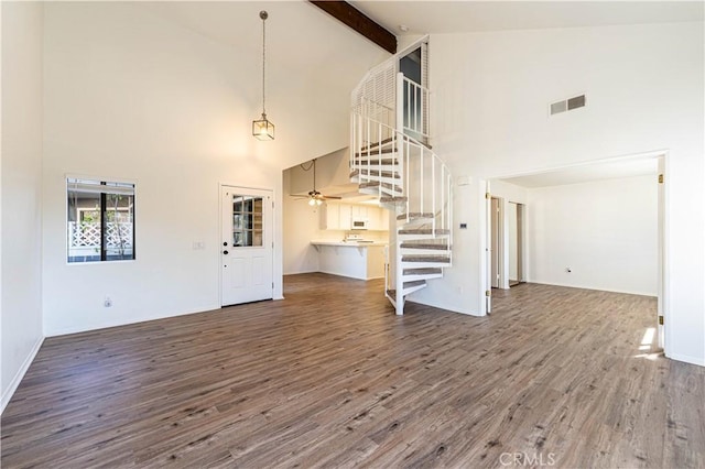 unfurnished living room featuring high vaulted ceiling, beam ceiling, ceiling fan, and hardwood / wood-style floors