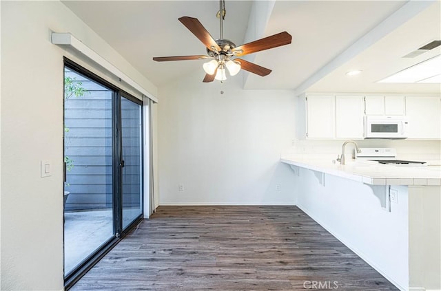 kitchen with white appliances, tile countertops, dark hardwood / wood-style floors, a breakfast bar area, and white cabinets