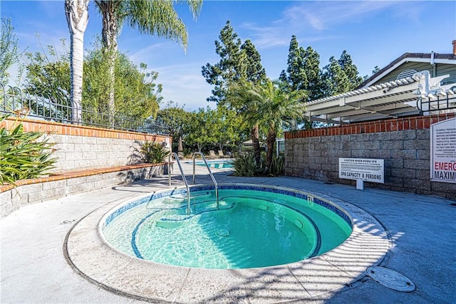 view of pool with a hot tub