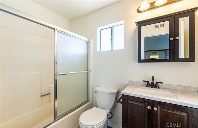 full bathroom featuring toilet, shower / bath combination with glass door, and vanity