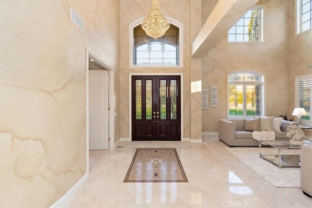 entryway featuring a chandelier and a towering ceiling