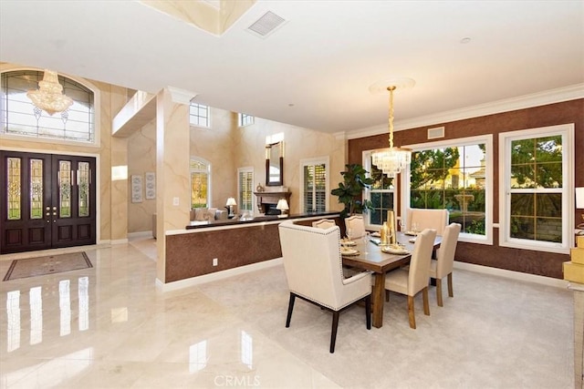 dining room with a notable chandelier, baseboards, visible vents, and ornamental molding