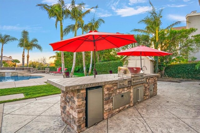 view of patio with area for grilling and an outdoor pool