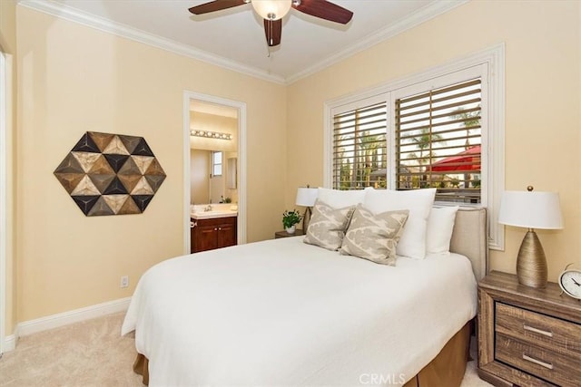 bedroom featuring ornamental molding, a ceiling fan, ensuite bath, baseboards, and light colored carpet