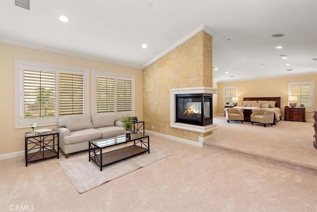 living area with plenty of natural light, ornamental molding, and carpet flooring