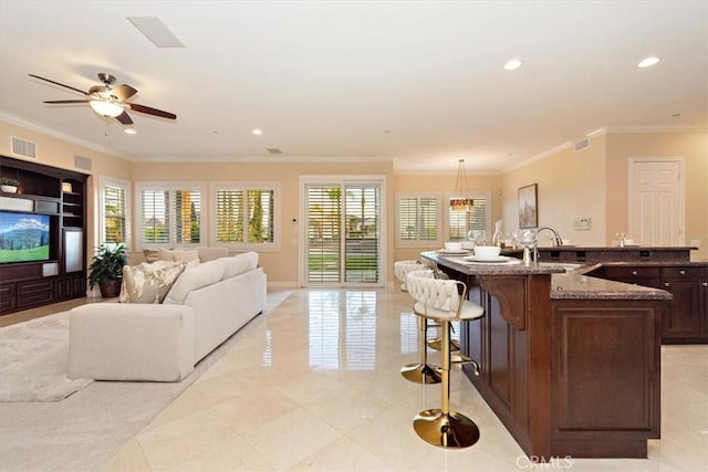 living room with recessed lighting, visible vents, a healthy amount of sunlight, and crown molding