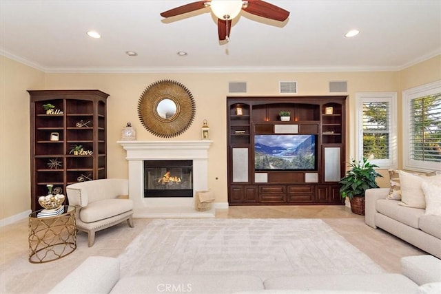 living room with visible vents, recessed lighting, a glass covered fireplace, and ornamental molding