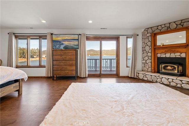 bedroom featuring a water view, dark hardwood / wood-style floors, and access to exterior