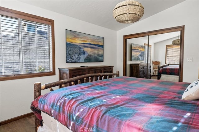 bedroom with lofted ceiling, a closet, and hardwood / wood-style flooring