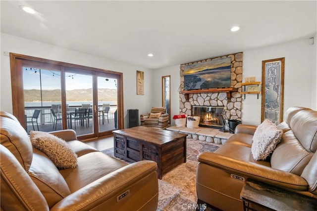 living room featuring a water view and a stone fireplace