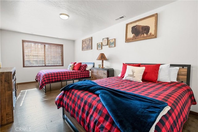 bedroom with dark wood-type flooring and a textured ceiling