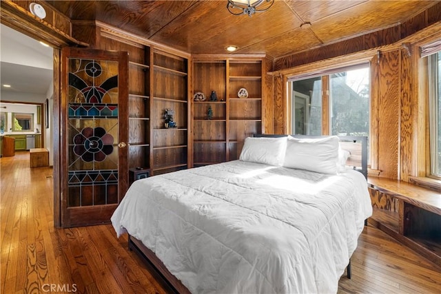 bedroom with wood walls, wooden ceiling, and hardwood / wood-style floors