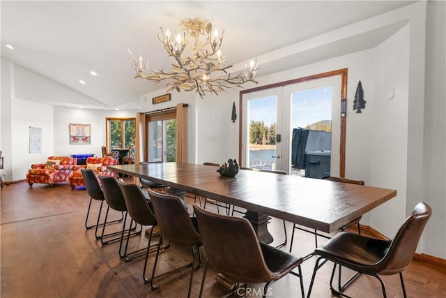 dining room featuring an inviting chandelier, lofted ceiling, and wood-type flooring