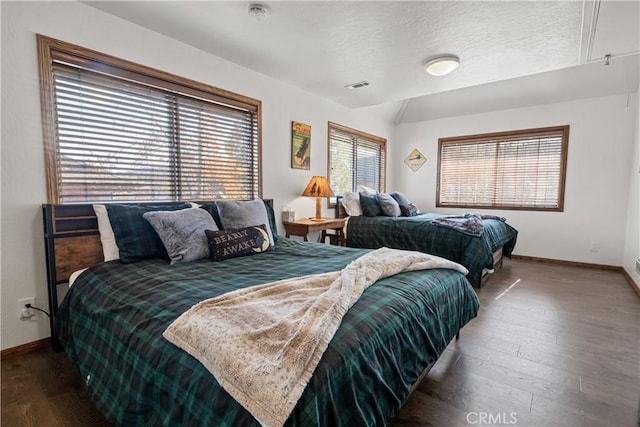 bedroom with lofted ceiling, dark wood-type flooring, and multiple windows