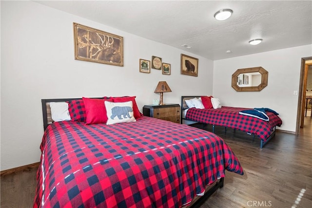 bedroom featuring a textured ceiling and dark hardwood / wood-style floors